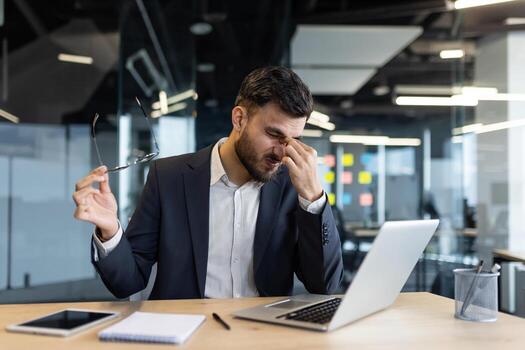 Executive with tension headache at the end of a workday